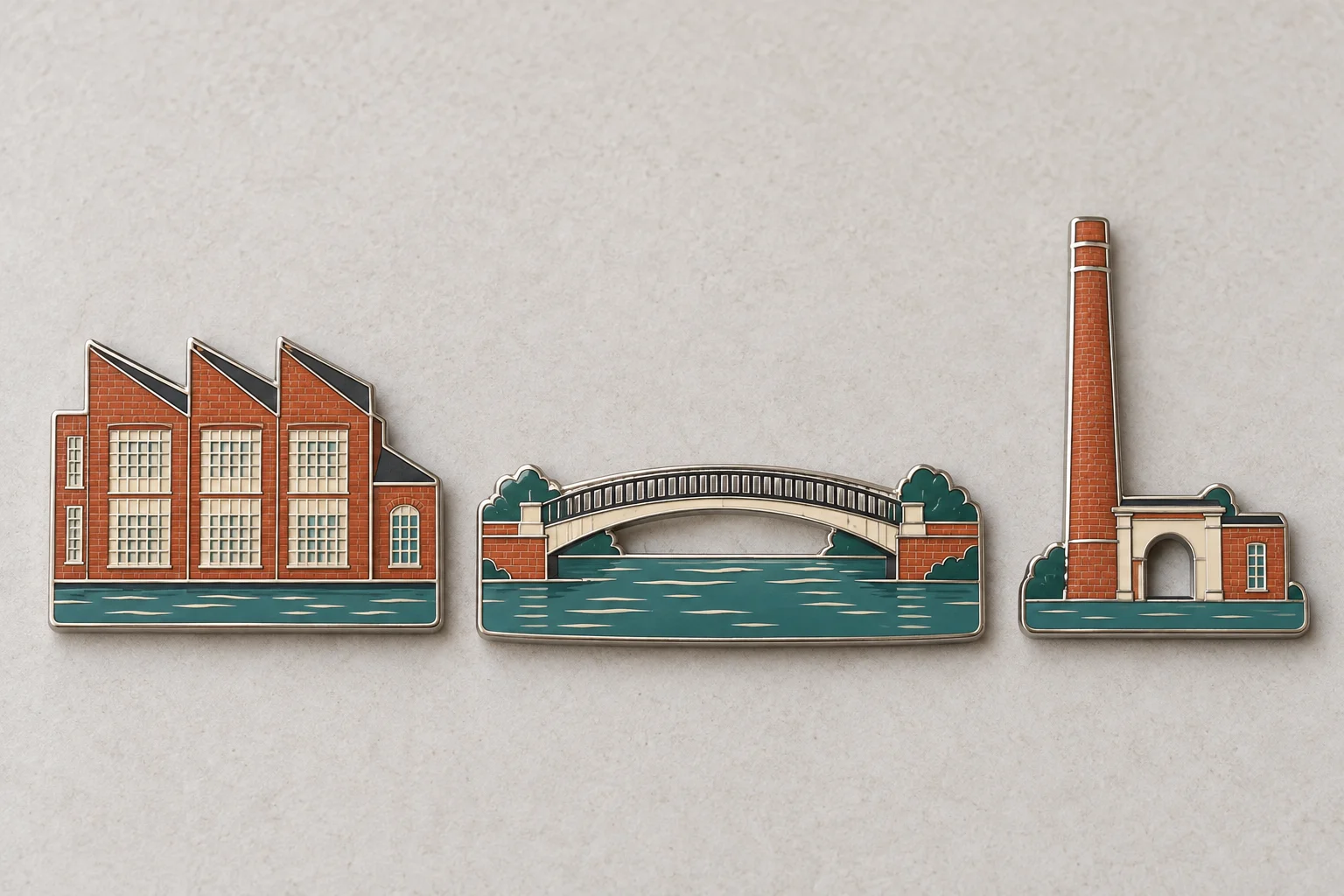 Three brick-red and teal metal magnets shaped like a factory, an arched bridge and a chimney entrance