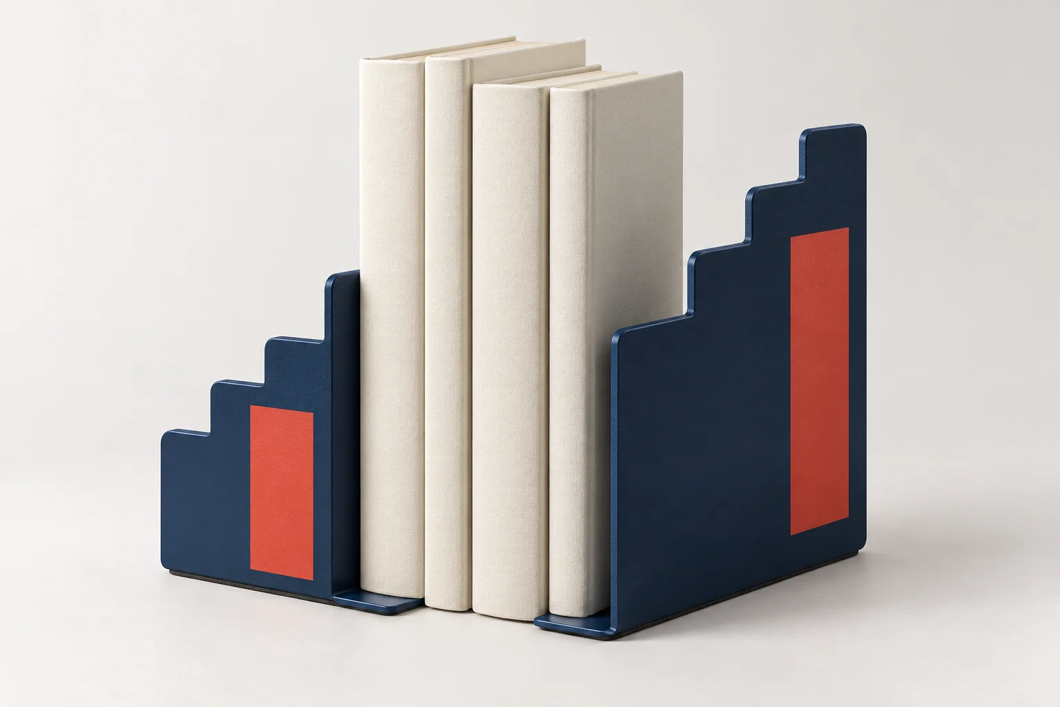 Pair of midnight-blue L-shaped metal bookends with different stepped heights and a red accent
