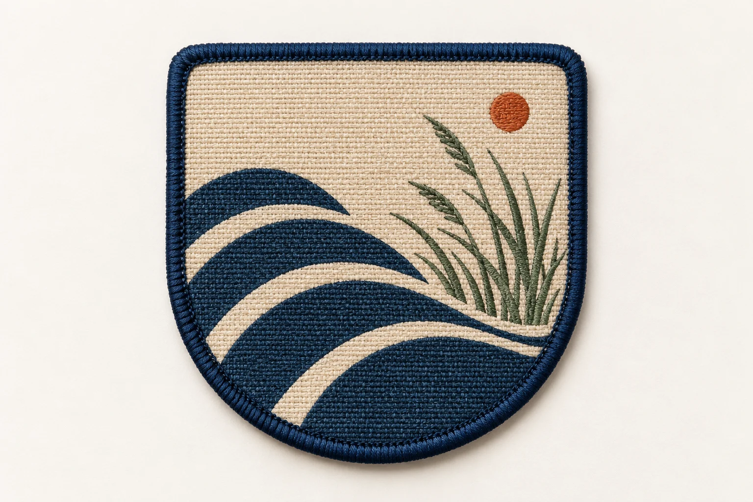 Shield-shaped woven patch with tide lines and dune grass